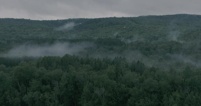 Drone flying through a beautiful foggy mountain top landscape, pan right