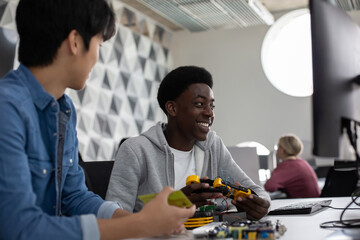 Male high school students working on a robotic arm in class