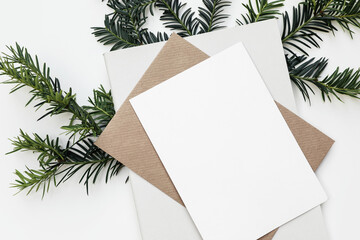 Festive closeup of Christmas blank greeting card, invitation mockup template. Craft envelope, diary...