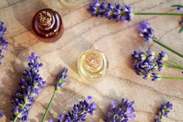 A transparent bottle of essential oil with blooming lavender twigs