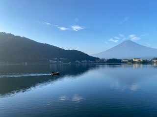 Fototapeta na wymiar Boat ride across the lake Kawaguchiko with beautiful clear Mt. Fuji view, sunny day with blue sky and the clear tip of the mountain, year 2022 August 27th, 6:27am Yamanashi prefecture, Japan 