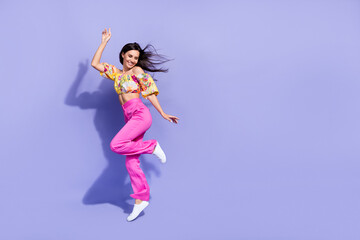Full size portrait of excited carefree girl jump rejoice enjoy free time isolated on purple color background