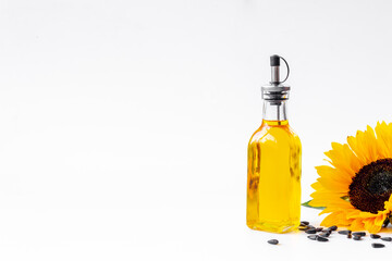 Close up of cooking oil with yellow sunflowers and black seeds