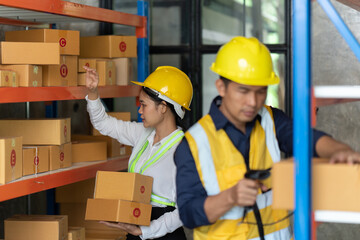 Asian female and male warehouse worker working at the storehouse. Logistics , supply chain and warehouse business concept.