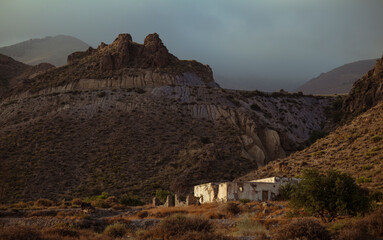 Landscape of abandoned house in oasis of desert against mountain. Almeria, Spain