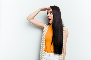 Naklejka premium Young caucasian woman isolated on white background looking far away keeping hand on forehead.