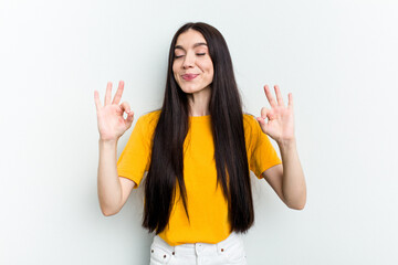 Young caucasian woman isolated on white background relaxes after hard working day, she is performing yoga.