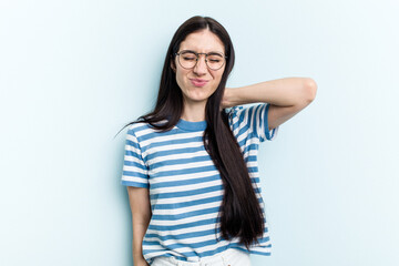 Young caucasian woman isolated on blue background having a neck pain due to stress, massaging and touching it with hand.