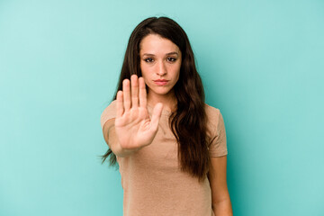 Young caucasian woman isolated on blue background standing with outstretched hand showing stop sign, preventing you. - obrazy, fototapety, plakaty