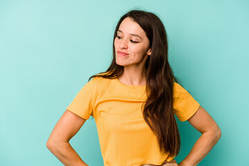 Obraz premium Young caucasian woman isolated on blue background dreaming of achieving goals and purposes