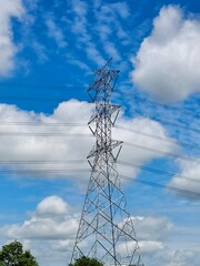 High voltage pole with blue sky ans white clouds.