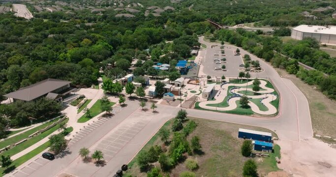 Round Rock play for all park sign aerial push in over park and parking structure drone 4k on sunny day