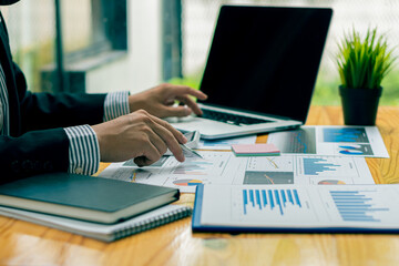 businessman holding pen with laptop graphing documents financial calculator deck for calculations and analysis