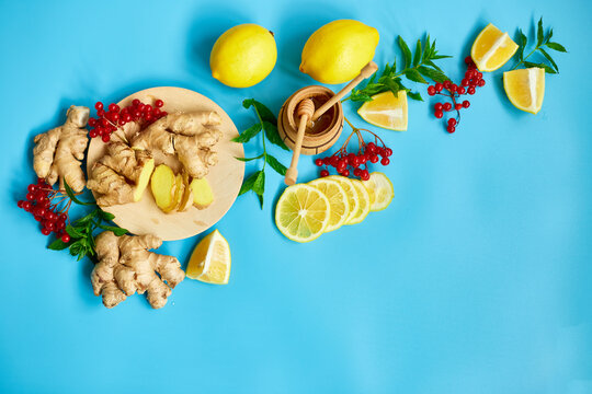 Flat Lay Of Immune Boosting Remedy, Immunity Boosting Foods Ginger, Lemon,  Honey,  Guelder Rose, Mint On Blue Background Top View, Copy Space.