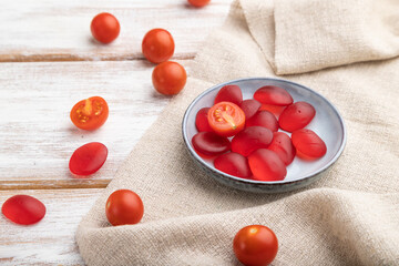 Jelly tomato candies on white wooden background. close up, side view.