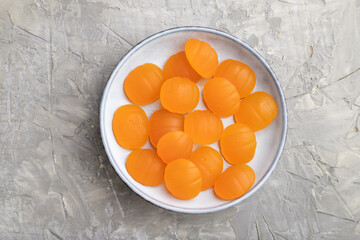 Jelly pumpkin candies on gray concrete background. close up, top view.