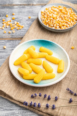 Jelly corn candies on gray wooden background. close up, side view.