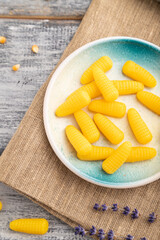 Jelly corn candies on gray wooden background. close up, top view.
