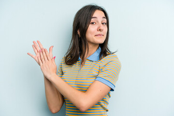 Obraz premium Young caucasian woman isolated on blue background feeling energetic and comfortable, rubbing hands confident.