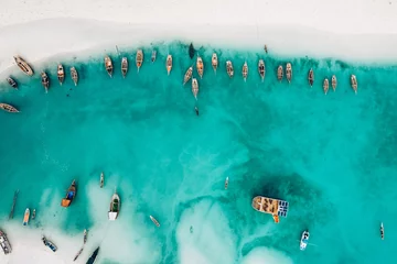 Fishing authentic african boat in beautiful turquoise Indian ocean, top view, aerial photo. Zanzibar island
