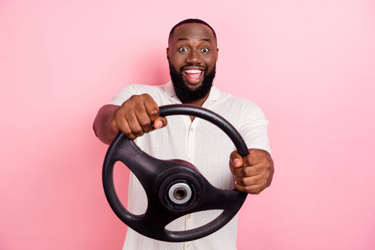 Photo of excited positive man hold wheel open mouth enjoy new car ride isolated on pink color background