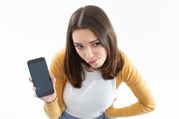 A young woman smashed her phone. The brunette holds the phone in her hands on a white isolated...
