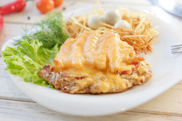 Small eggs in a nest made with potatoes on a white plate