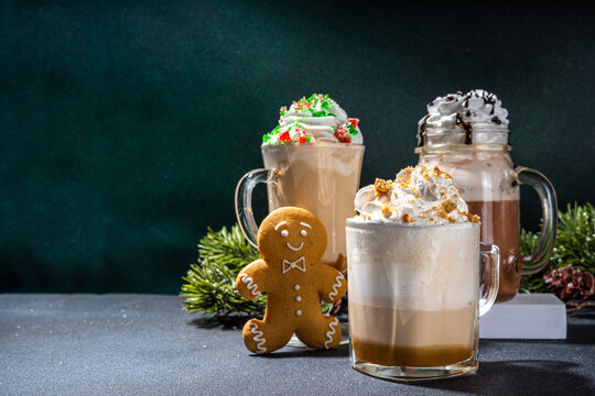 Autumn winter coffee latte set, Autumn winter coffee drink assortment with various topping - gingerbread caramel, mocha chocolate, candy cane peppermint latte in different cups, over dark background