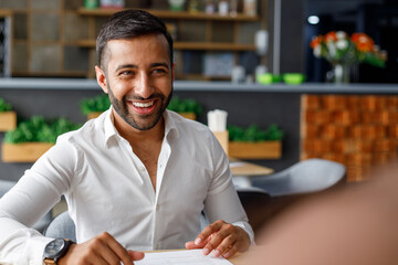 Portrait of smiling young male professional sitting in cafe