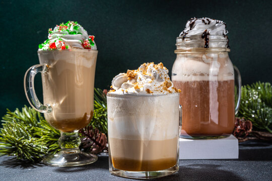 Autumn winter coffee latte set, Autumn winter coffee drink assortment with various topping - gingerbread caramel, mocha chocolate, candy cane peppermint latte in different cups, over dark background
