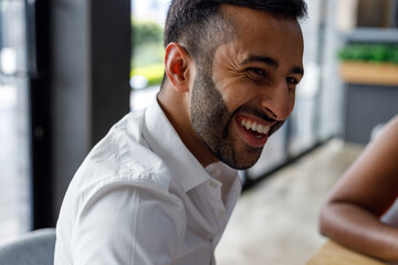 Portrait of smiling young male professional sitting in cafe