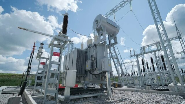 High voltage transformer against the blue sky. Electric current redistribution substation
