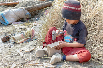 a young boy is learning and fixing wooden boxes