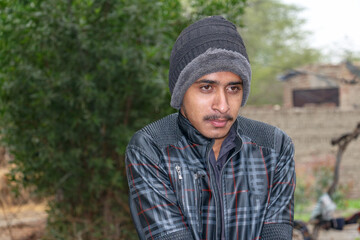 a homeless child is covering his body and face with a warm shawl in extremely cold weather 