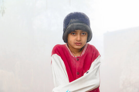 A Homeless Child Is Covering His Body And Face With A Warm Shawl In Extremely Cold Weather 