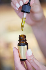Close Up Of Hand Holding Dropper With CBD Medicinal Cannabis Oil