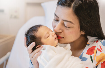 Closeup portrait of young asian Indian hispanic mother day holding newborn baby with copy space....