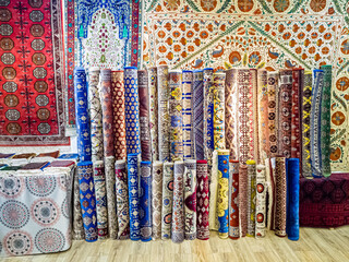 Ethnic carpet, ornamental folk bags, many ornate pillows with embroidery in asian shop, store. Asian market, trade fair in Uzbekistan. Traditional national ornament. Asian handicraft, Uzbek craft