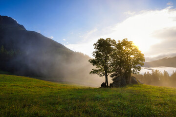 Beautiful summer sunrise scene in the mountains with spectacular sky and fog. Mystical landscape. Location place Alps, Europe.
