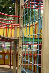 Fototapeta na wymiar Children's playground with climbing rope net on summer day
