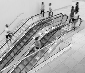 Blurred image of people on the escalator in the mall