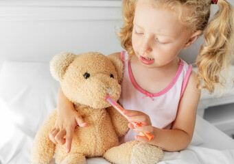 The child treats the bear. Play during illness.