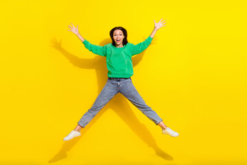 Fototapeta na wymiar Full size photo of overjoyed pretty girl jumping raise hands make star figure isolated on yellow color background