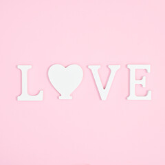 Love wooden white letters on pastel pink background.