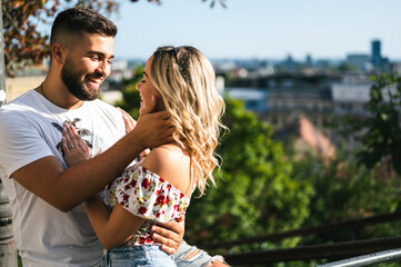 Summer image of smiling beautiful young couple hugging and looking at each other in golden hour