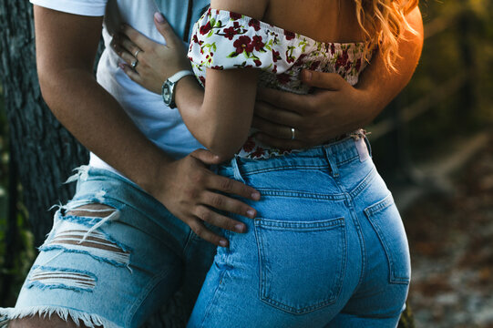 Young passionate couple in love hugging outdoor. Fit buttocks tight blue jeans woman and man.