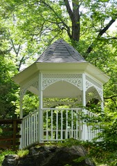 A white gazebo surrounded by green trees near Blue Spring Heritage Center, Eureka Springs,...