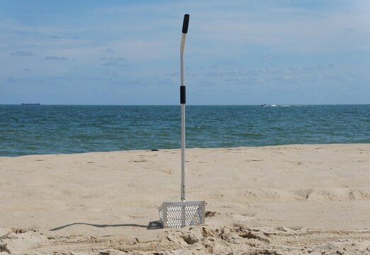 A metal sand fleas rake by the beach
