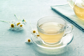 Obraz na płótnie Canvas Chamomile tea in a cup with loose flowers, herbal medicine treatment