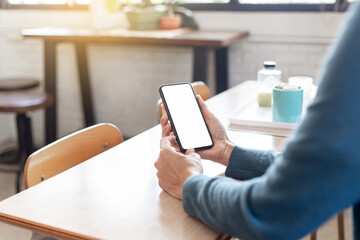 cell phone blank white screen mockup.hand holding texting using mobile on desk at office.background empty space for advertise.work people contact marketing business,technology